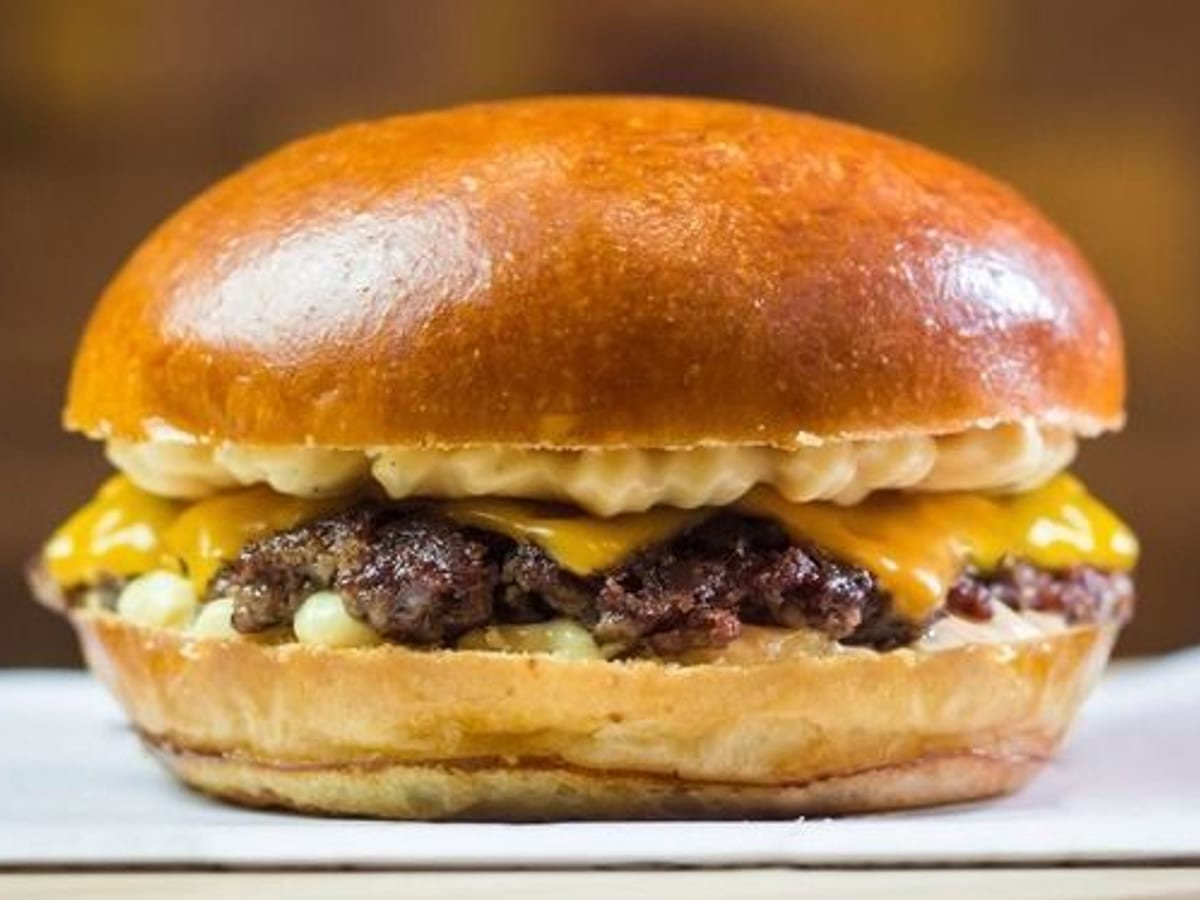 برجر سماش لحم — برجر سماش لحم بقري بالجبن، محمّر إلى الكمال، قضمة عصيرية ولذيذة | Cock "N" Bull, Sharjah