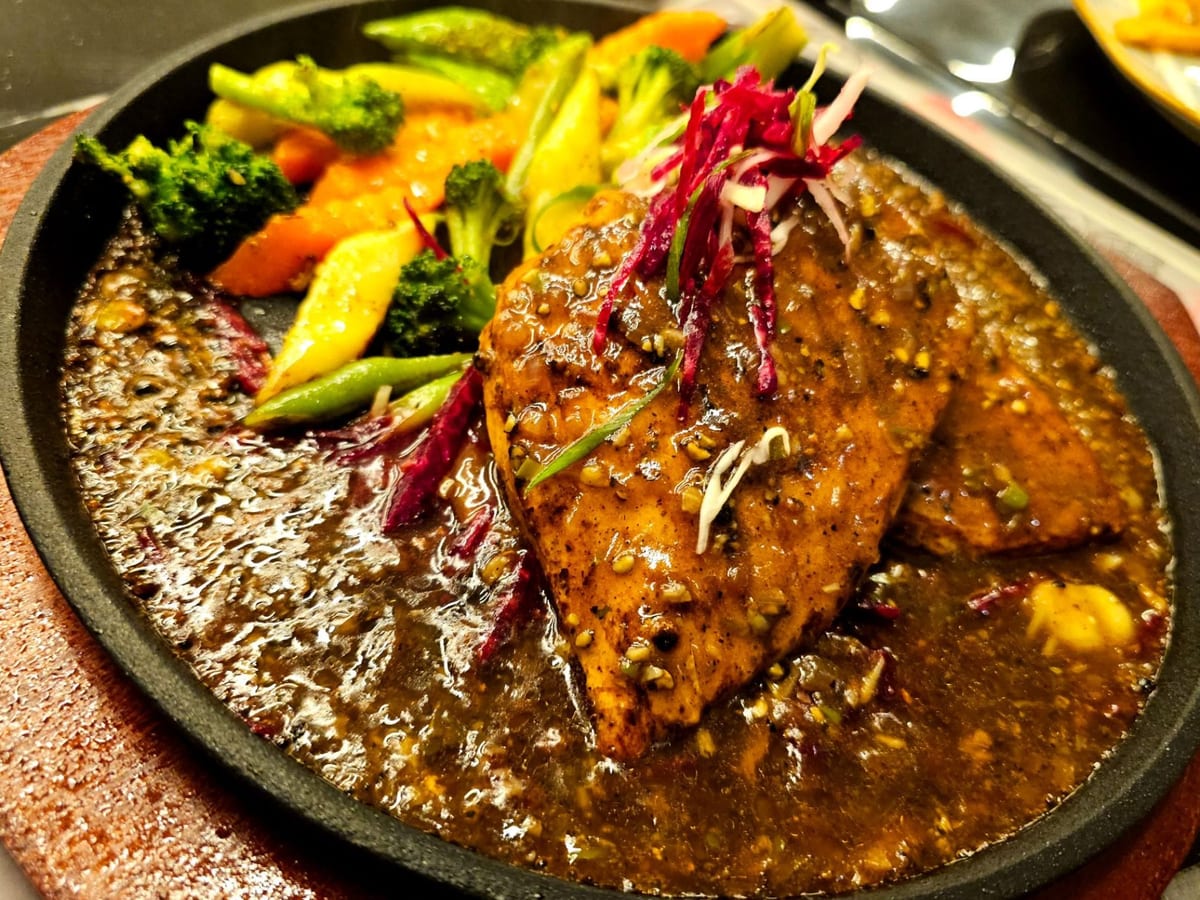 ستيك الفلفل الأسود — ستيك دجاج أو لحم بقري طري بنكهة الفلفل الأسود المطحون لمتعة لاذعة-حارة، مع خضار نابضة بالحياة في طبق آسيوي كلا… | Cock "N" Bull, Sharjah