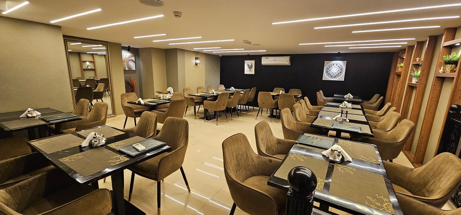 صالة طعام عائلية في الطابق العلوي بمطعم كوك أن بول الشارقة بكراسي مخملية بنية وإضاءة دافئة