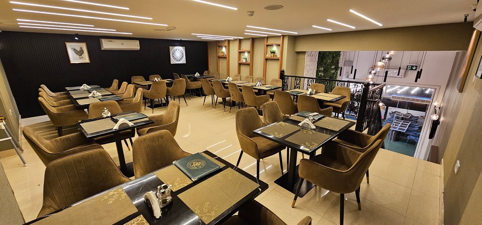 منظر واسع لصالة الطعام العلوية في كوك أن بول، المجرة - مقاعد بنية فاخرة وطاولات للمجموعات