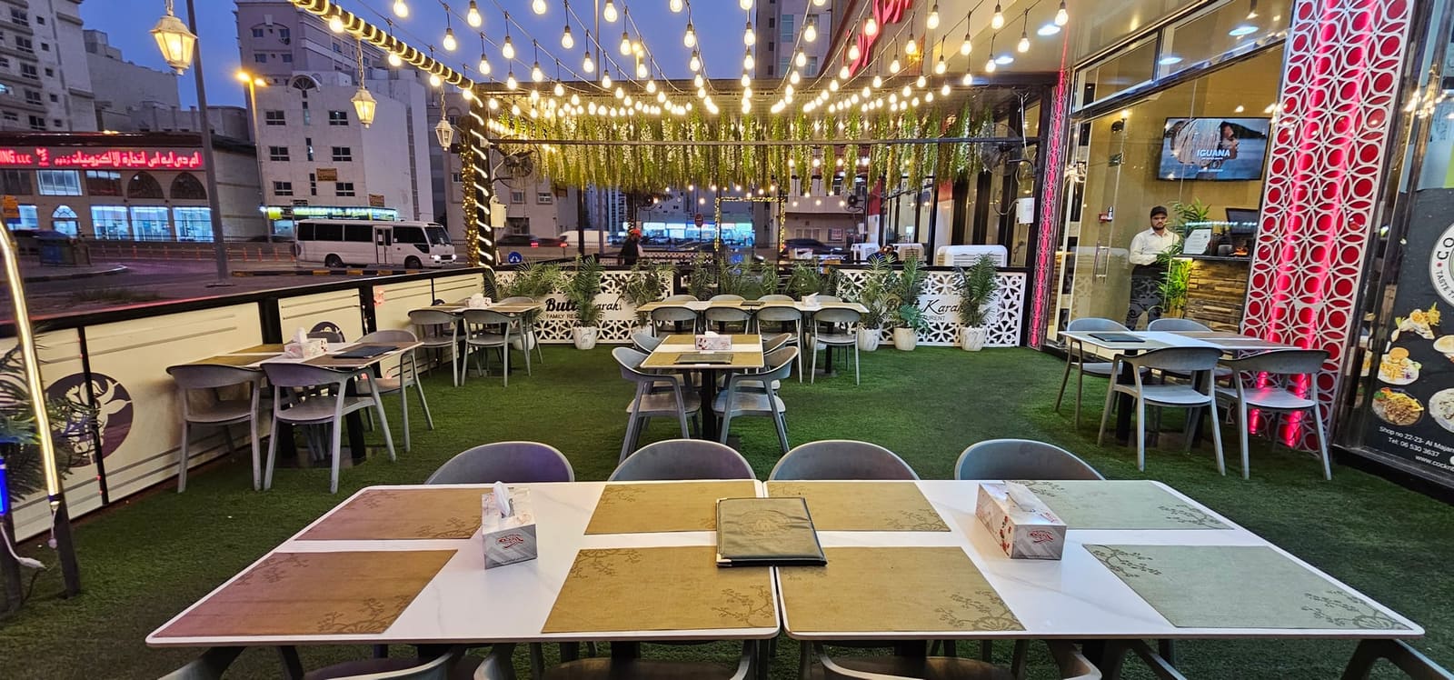 جلسات تراس في كوك أن بول الشارقة مع أحواض نباتات وإضاءة معلقة - عشاء في الهواء الطلق تحت سماء الشارقة