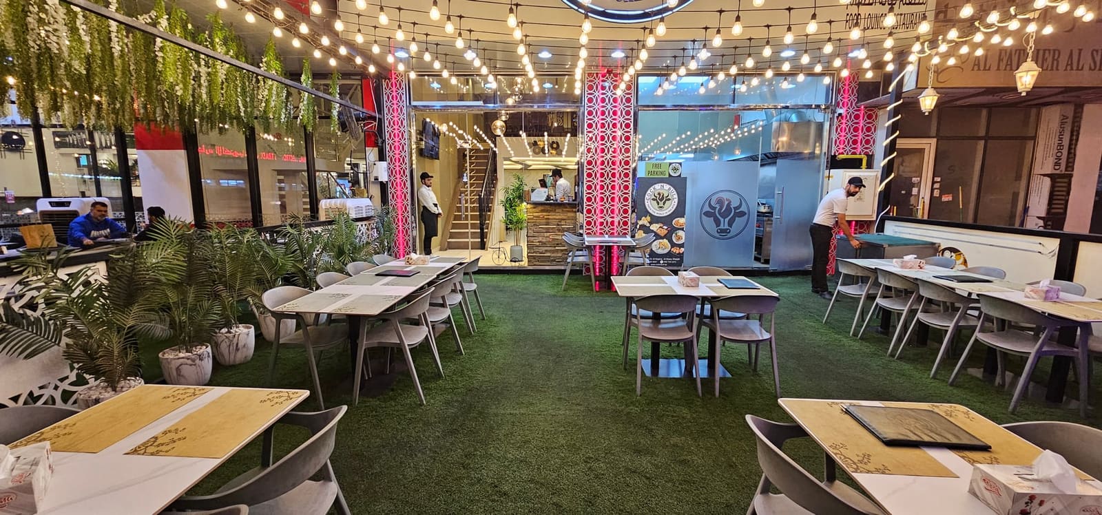 طاولات تراس خارجية في كوك أن بول الشارقة - منطقة مغطاة في الهواء الطلق بإضاءة معلقة